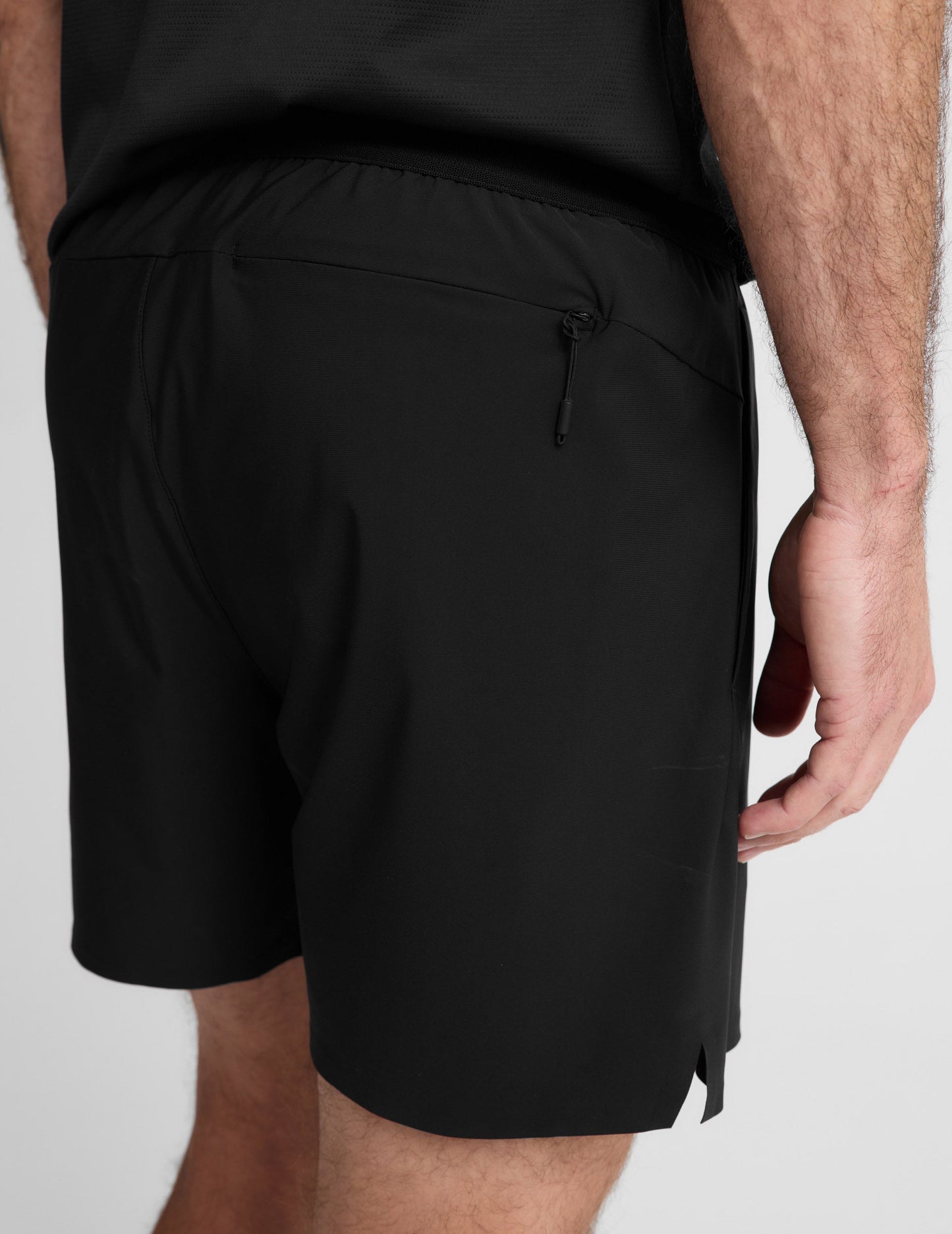 Man wearing Black WarpLite Range Lined Short™ with a black t-shirt, showing a rear view and zippered back pocket.