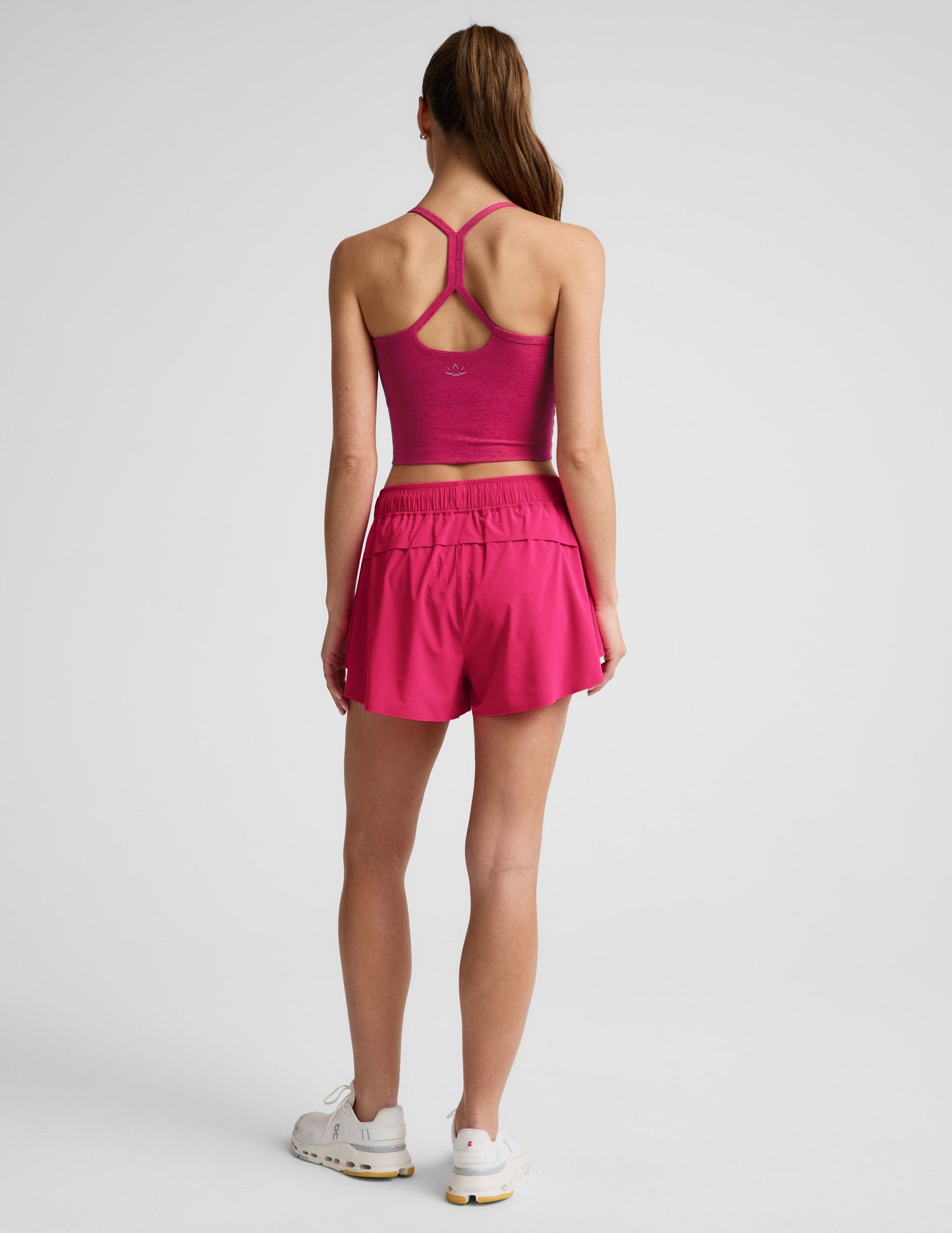 Rear view of woman wearing Pink Solemate™ 2.5" Short paired with a pink racerback tank top and white sneakers.