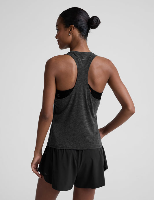 Woman wearing a dark gray tank top and black shorts on a light gray background.