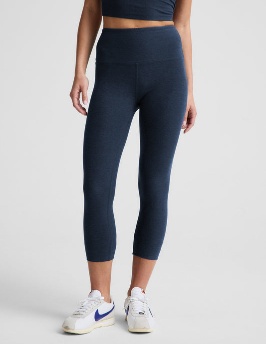 Woman wearing Dark blue Spacedye Walk And Talk High Waisted Capri Legging™ paired with a matching tank and white sneakers.