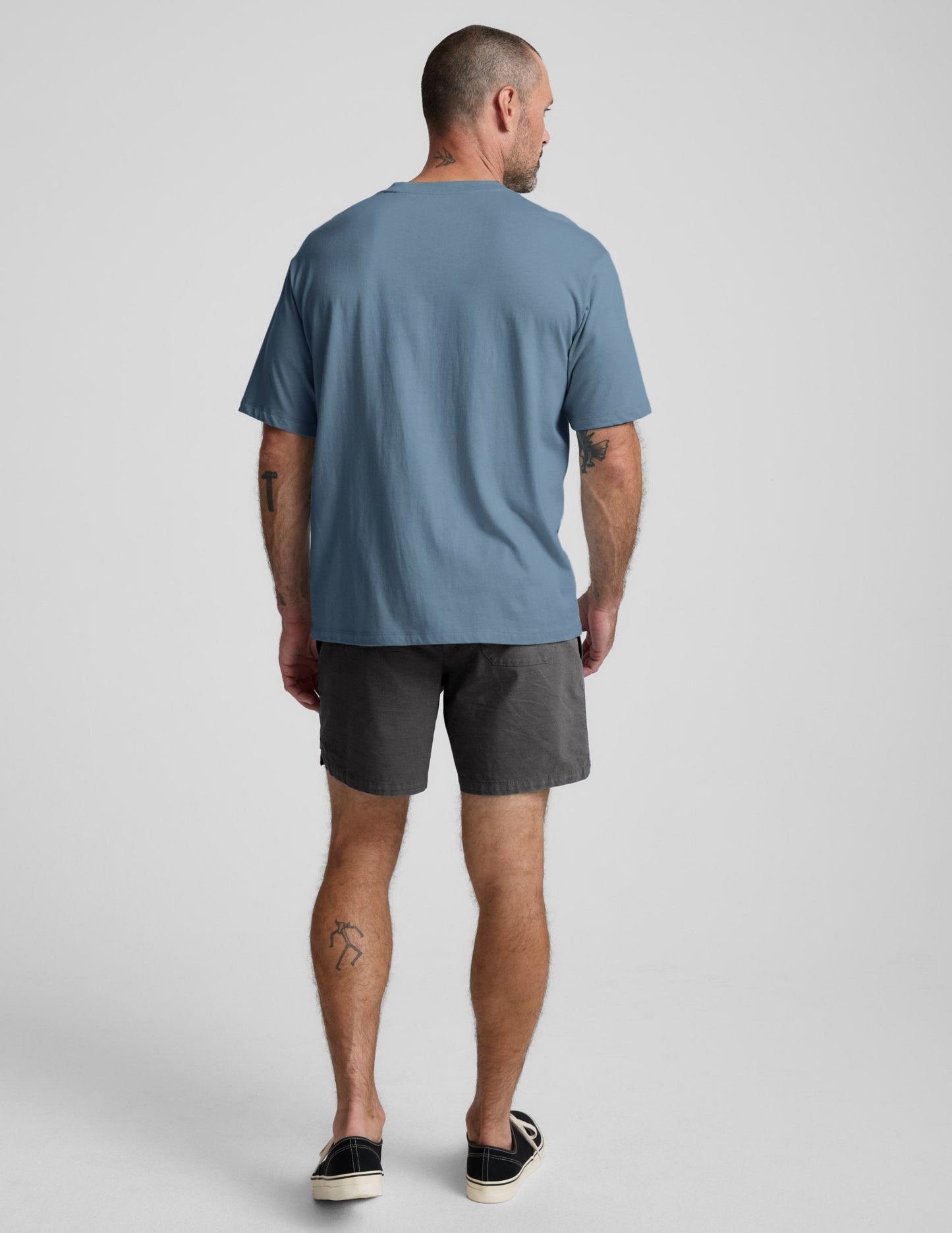 Rear view of a man wearing dark gray Saturday Men's Shorts, featuring a regular fit and mid-thigh length.