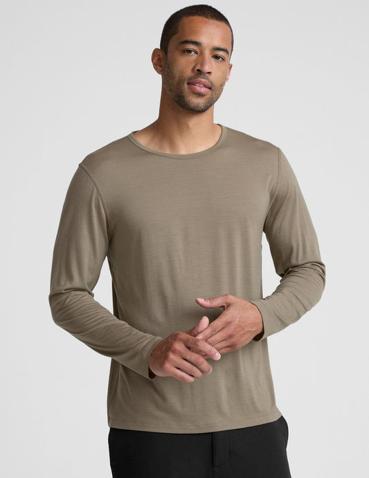 Man wearing a brown long-sleeve shirt against a plain background.