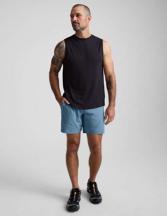Man wearing blue Pivotal 2.0 Men's Lined Short 7" with elastic waistband and side pockets, standing in a studio.