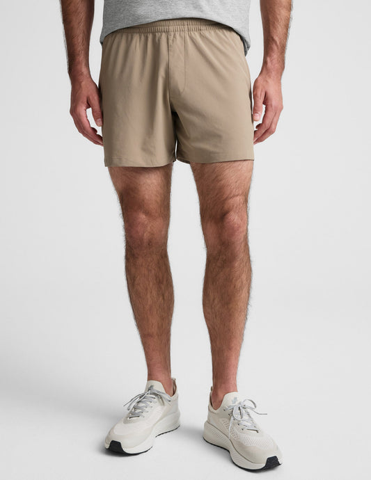 Front view of Pivotal 2.0 Men's Short 5" in beige, featuring a relaxed mid-thigh fit and a gathered elastic waistband.