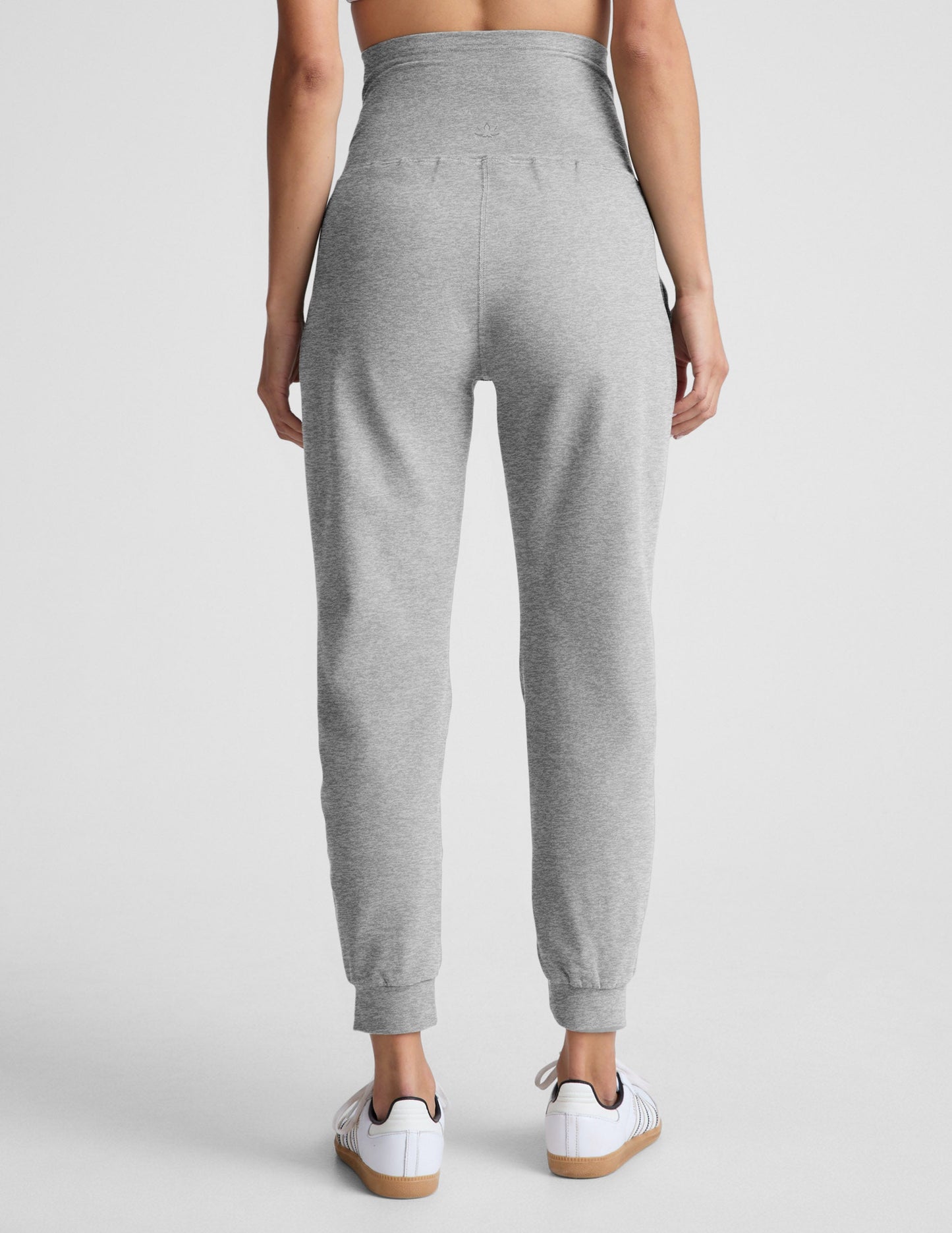 Rear view of woman wearing Gray Spacedye Beyond the Bump Maternity Midi Jogger™ paired with white sneakers.