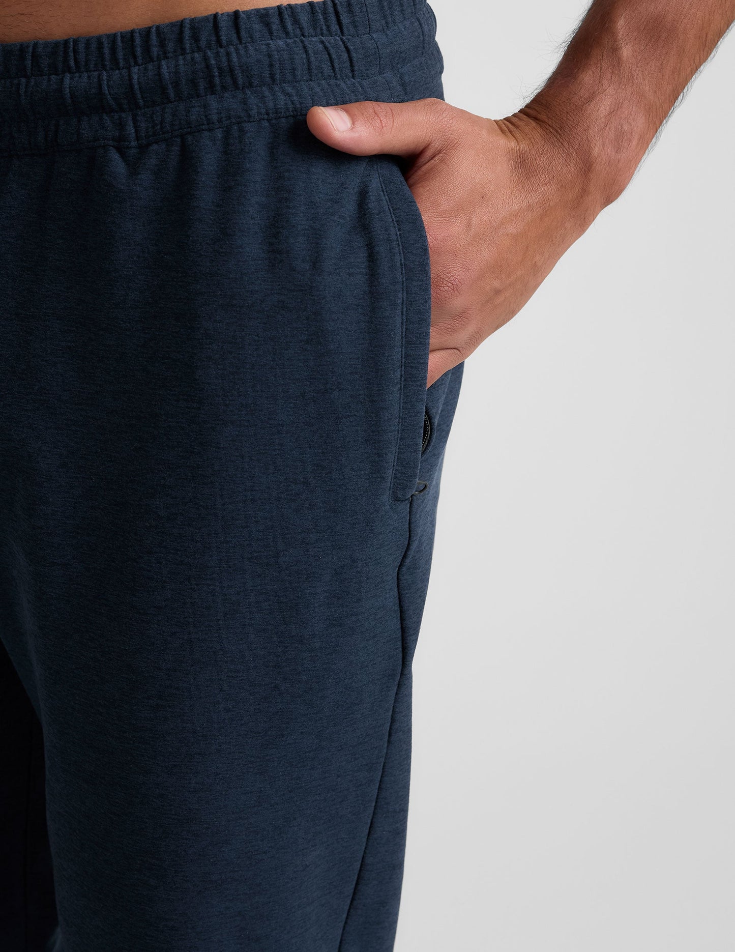 Close-up of the Spacedye Freefit Men's Zipper Pockets Jogger in navy marled fabric featuring a side zipper pocket and hand.