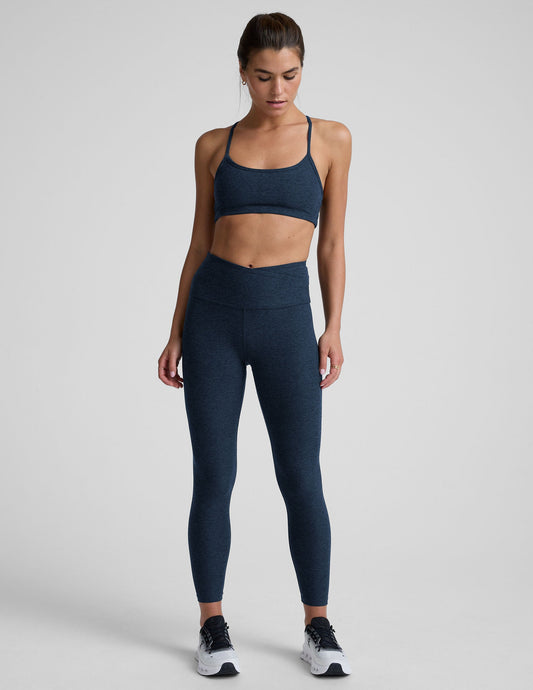Woman wearing a navy athletic outfit on a light gray background