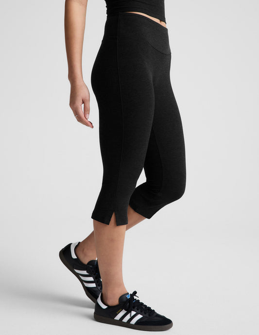 Side view of Spacedye Mid-Rise Slit Pedal Pusher Legging in black with side hem slits and a mid-calf cropped length.