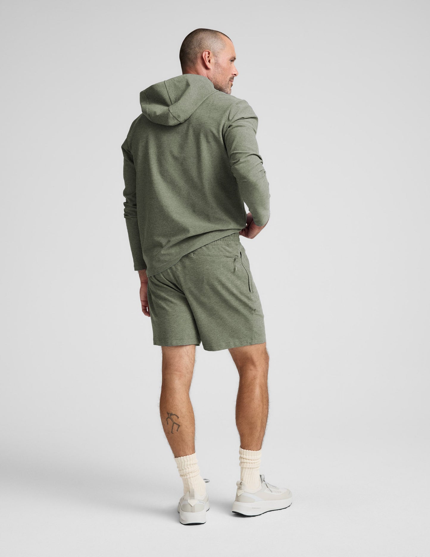Man wearing Olive Spacedye Unlimited Men's Short™ paired with a matching olive hoodie and white socks, rear view.