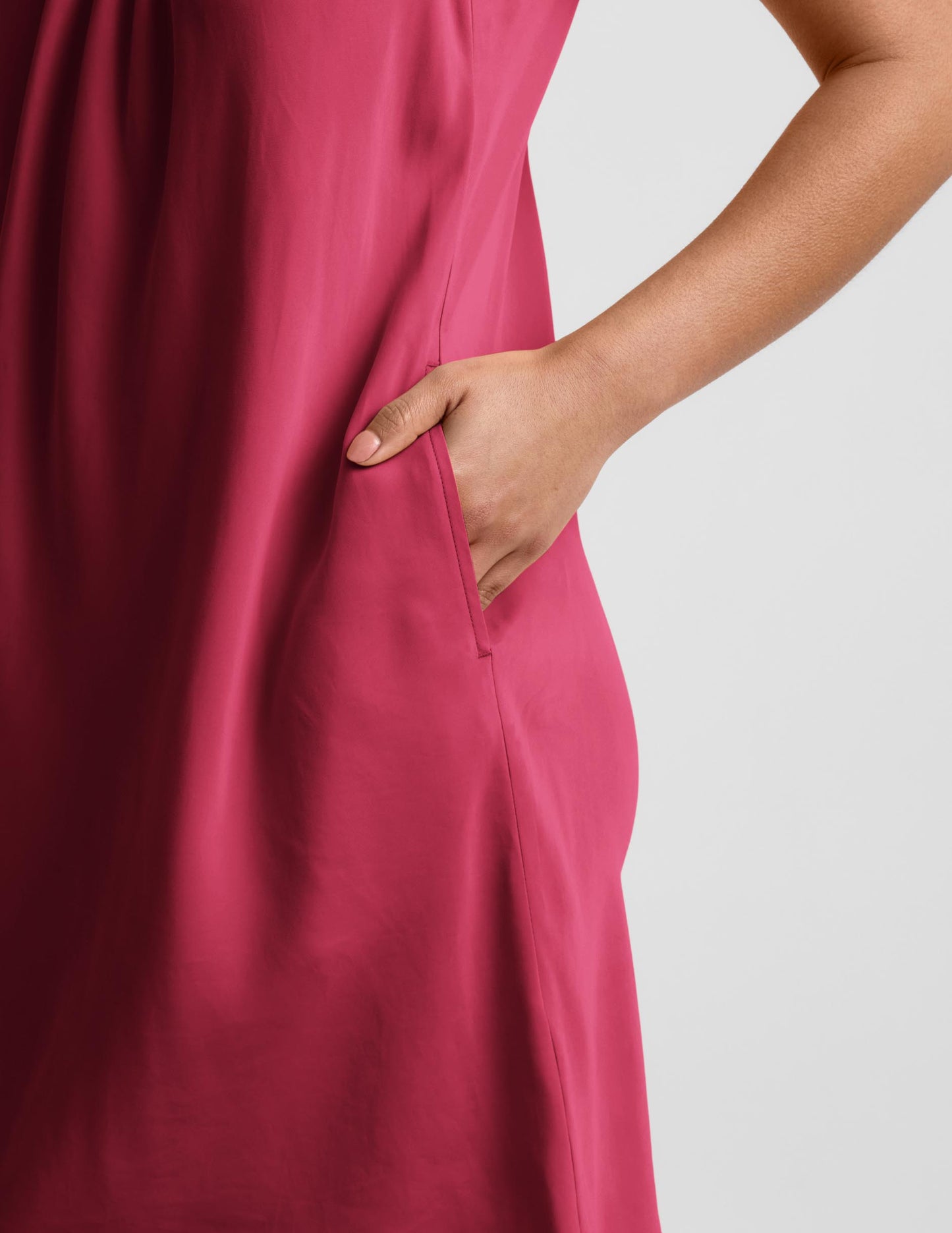 Woman wearing a red mini tank dress against a plain background.
