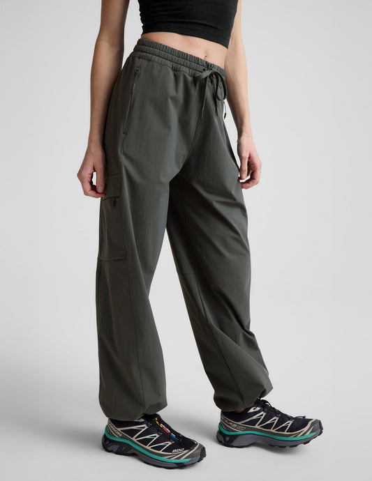 Woman wearing Java Peak Pant™ with a cargo pocket and bungee hem, paired with a black crop top and sneakers.