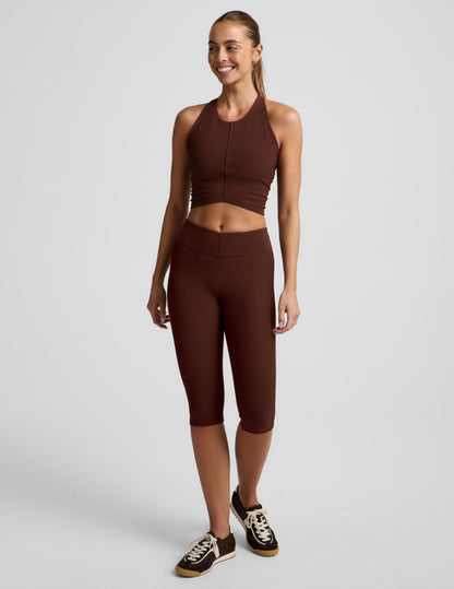 Woman wearing Brown Impulse™ Ribbed V-Waist Pedal Pusher Legging paired with a matching crop top and brown sneakers.