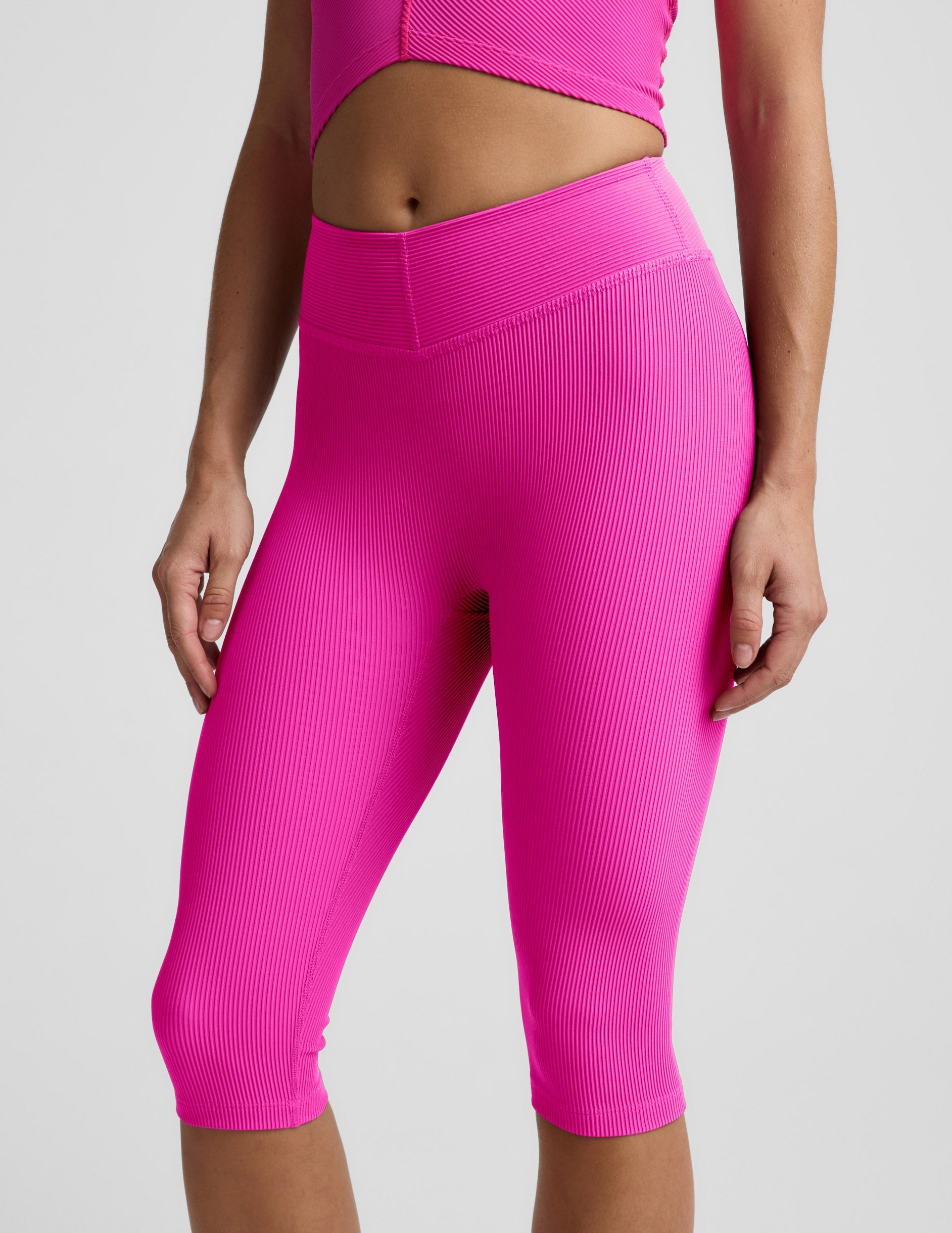 Woman wearing Pink Impulse Ribbed V-Waist Pedal Pusher Legging paired with a matching pink top.