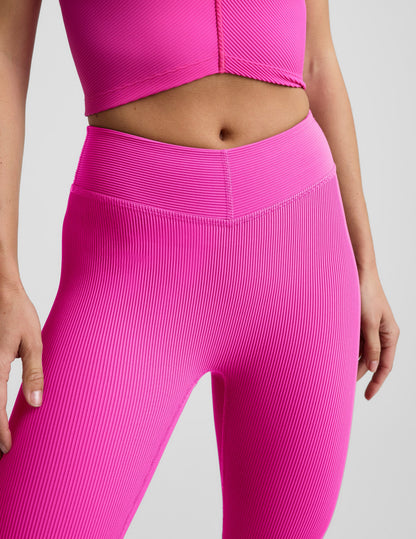Woman wearing Pink Impulse Ribbed V-Waist Pedal Pusher Legging™ paired with a matching pink ribbed top.