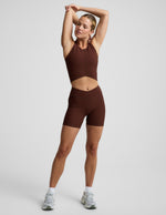 Woman wearing Brown Impulse™ Ribbed V-Waist 5" Biker Short paired with a matching cropped tank and sneakers.