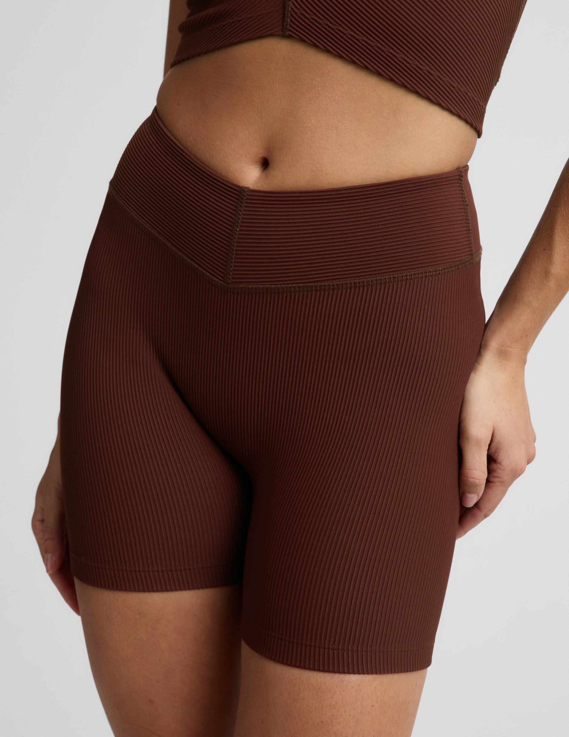 Woman wearing Brown Impulse Ribbed V-Waist 5" Biker Short™ with a ribbed V-waistband, paired with a matching top.