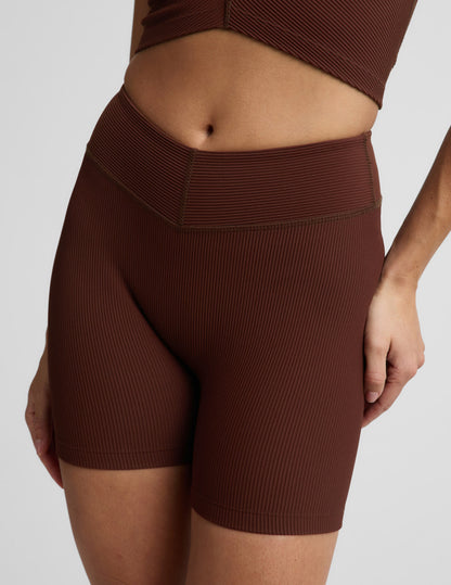 Woman wearing Brown Impulse Ribbed V-Waist 5" Biker Short™ with a ribbed V-waistband, paired with a matching top.