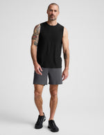 Man wearing Gray WarpLite™ Range Lined Short with a 6-inch inseam, paired with a black tank top and black sneakers.