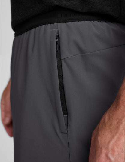 Side profile of man wearing Gray WarpLite Range Lined Short™ paired with a black top, detailing the vertical zip pocket.