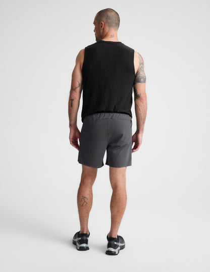 Man wearing Gray WarpLite Range Lined Short™ paired with a black tank top and sneakers, Rear view.