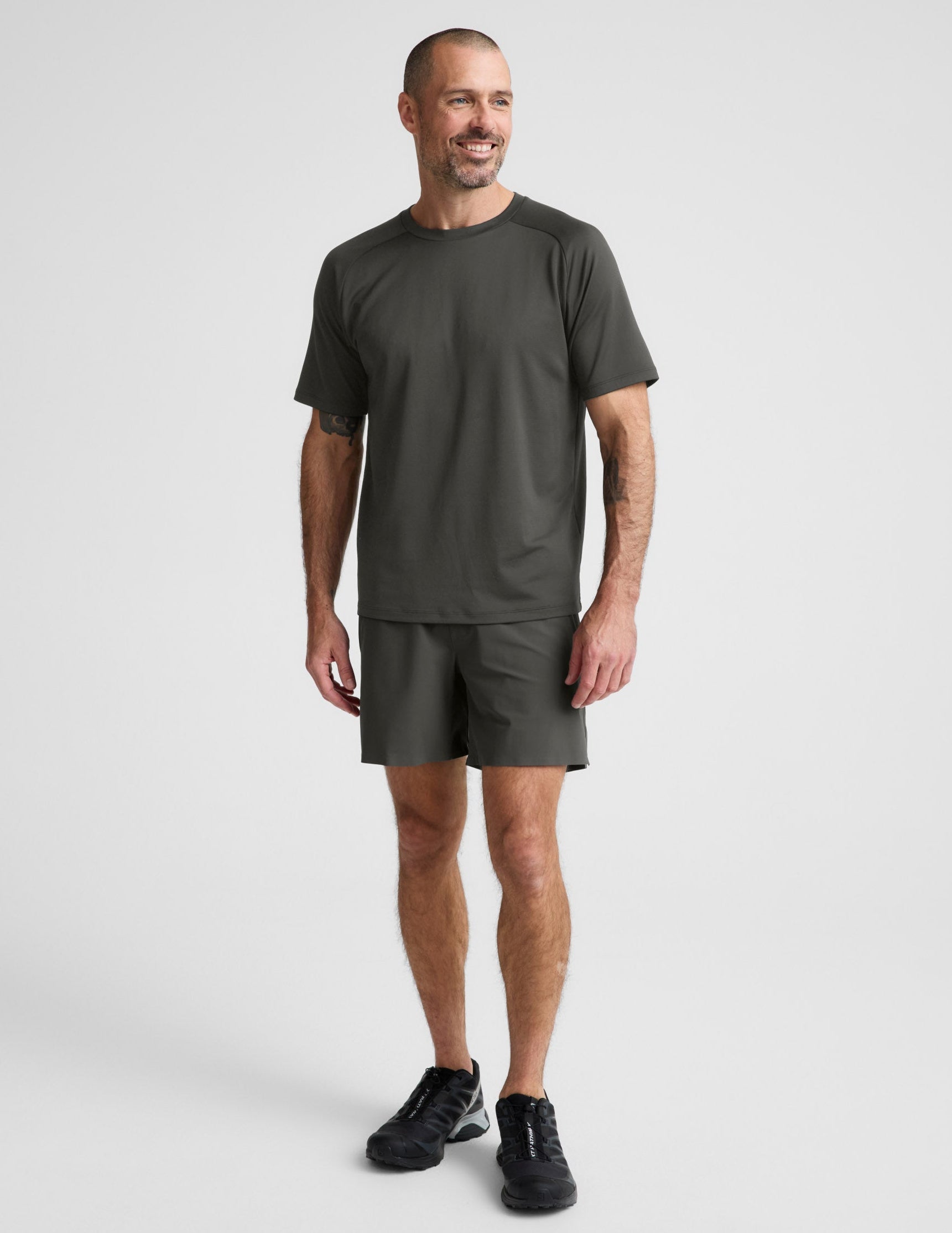 Man wearing Olive WarpLite Range Lined Short™ paired with a matching t-shirt and black sneakers.