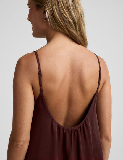 Woman wearing a brown maxi cupro dress against a plain background.