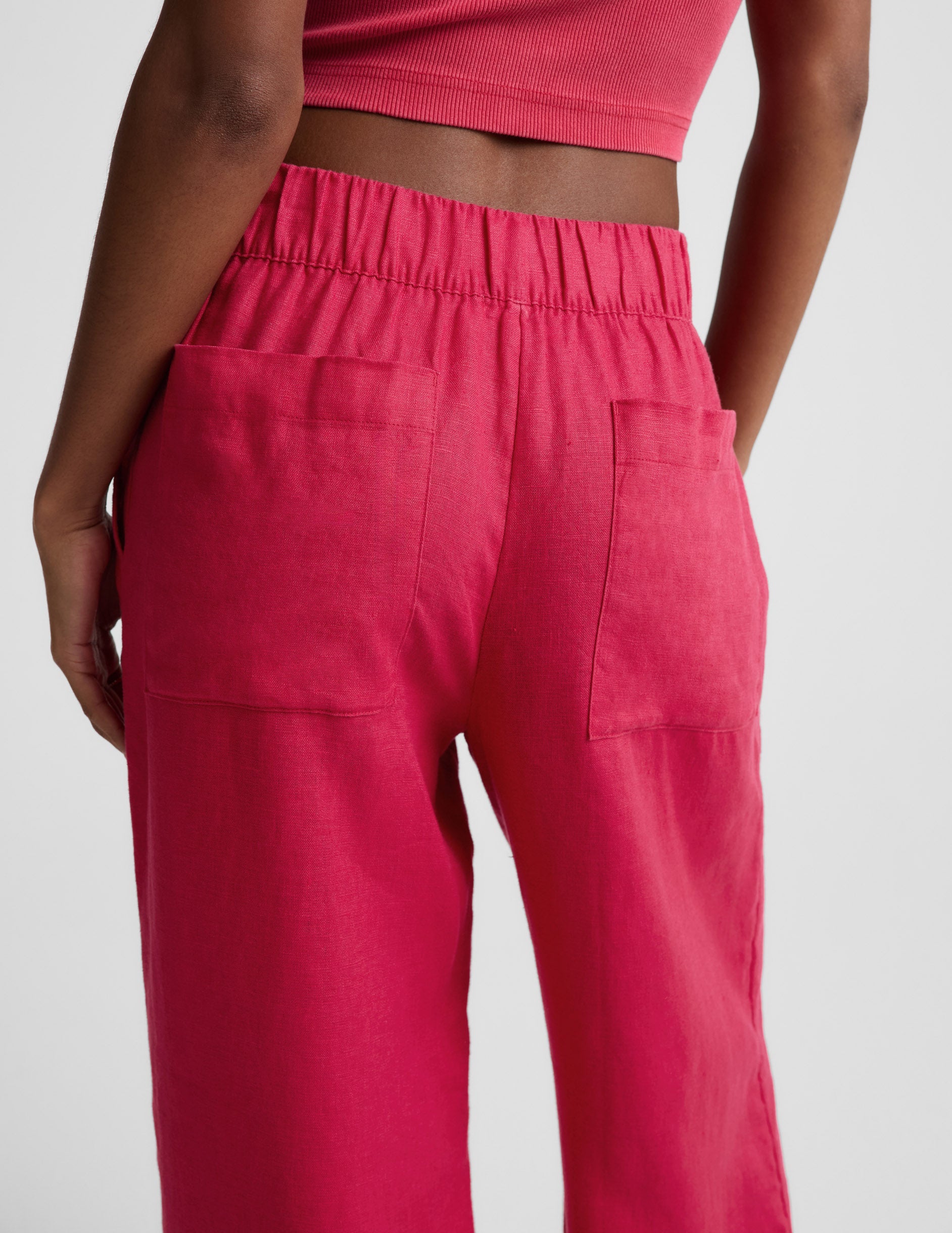 Woman wearing Pink SoftWash Linen Easy Wide Leg Pant 29" with a matching crop top, rear view showing the elastic waistband.