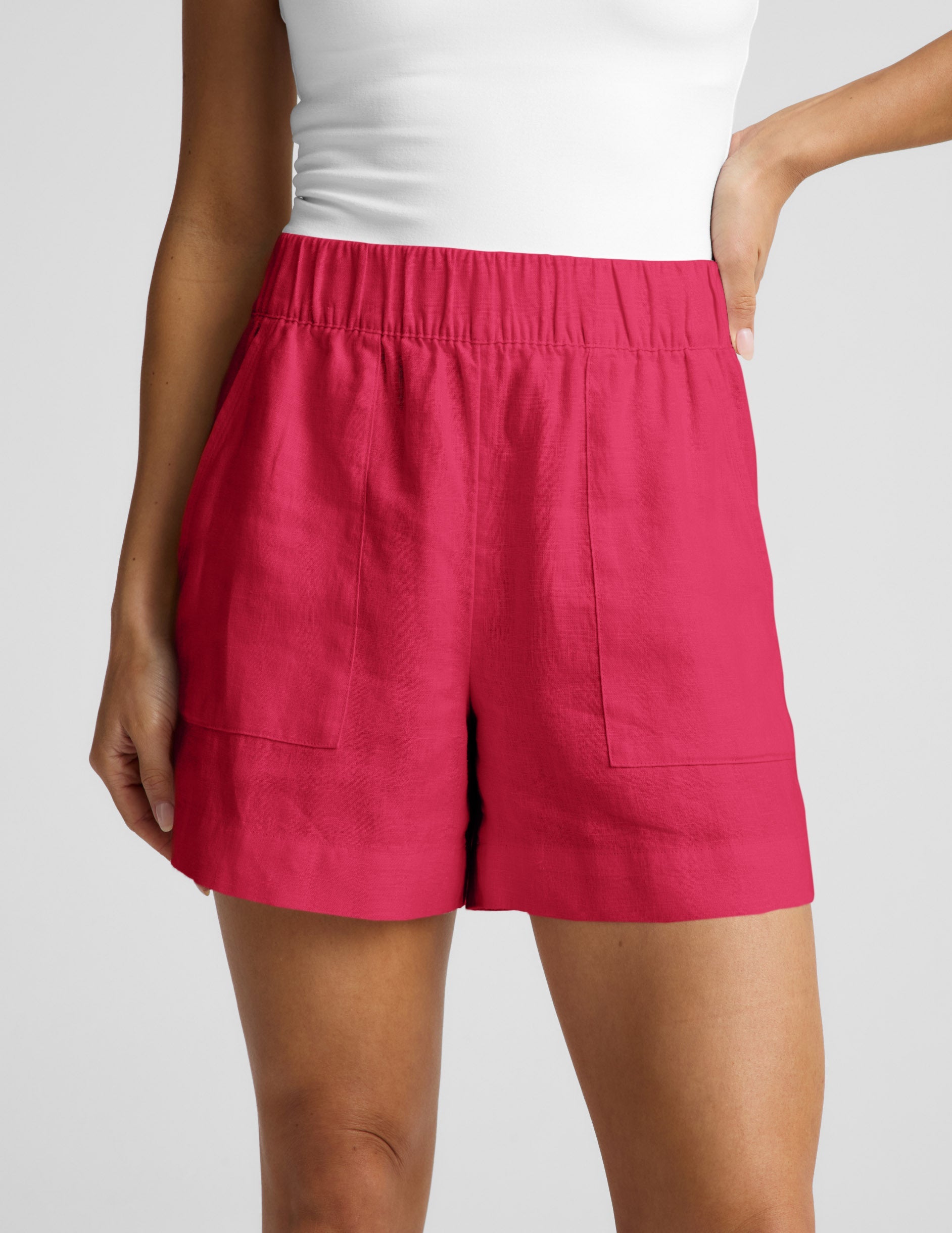 Woman wearing Fuchsia SoftWash™ Linen Easy Short with patch pockets, paired with a white tank top.