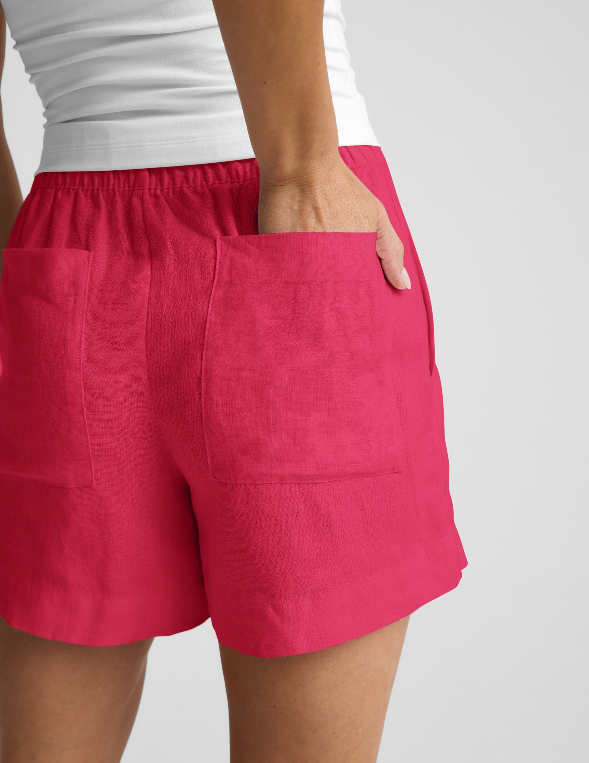 Woman wearing Fuchsia SoftWash™ Linen Easy Short with a white top, showing the rear view and back patch pockets.