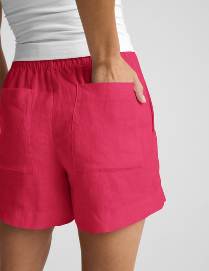 Woman wearing Fuchsia SoftWash™ Linen Easy Short with a white top, showing the rear view and back patch pockets.