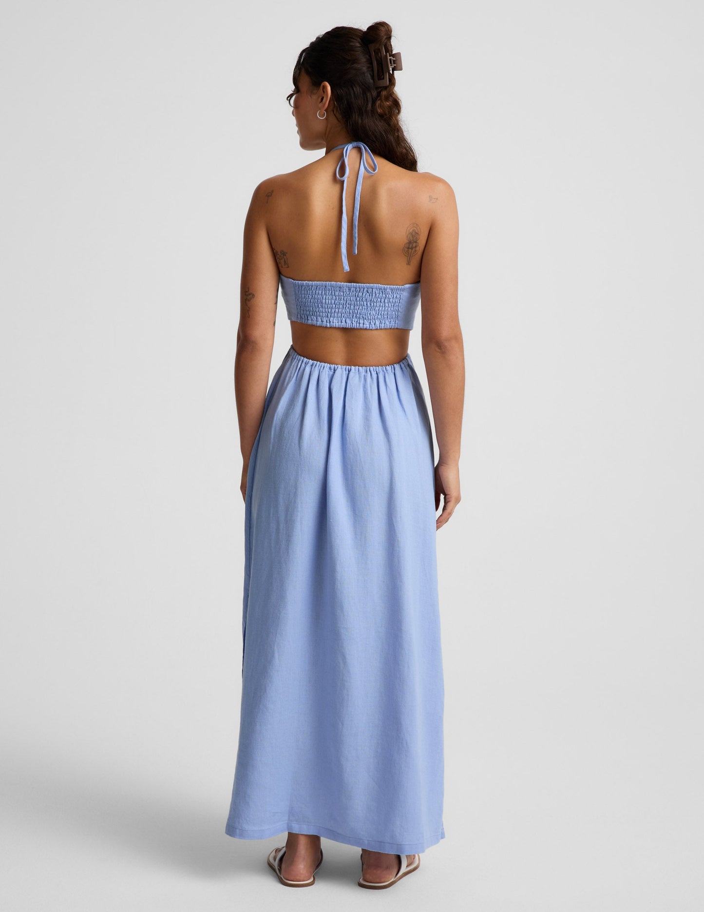 Woman wearing a light blue dress on a gray background.