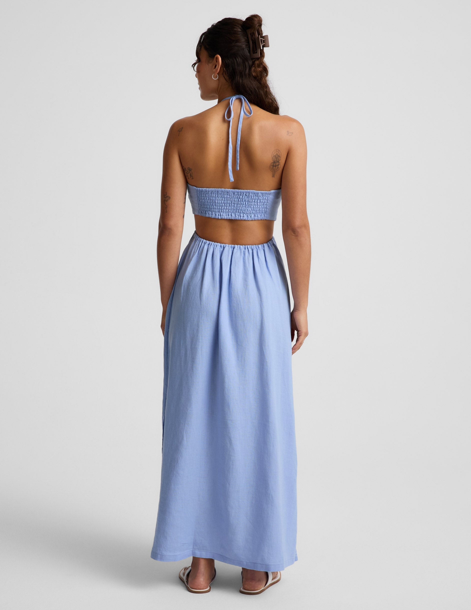 Woman wearing a light blue dress on a gray background.