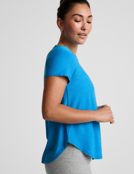 Woman wearing a blue t-shirt and gray biker shorts against a plain background.