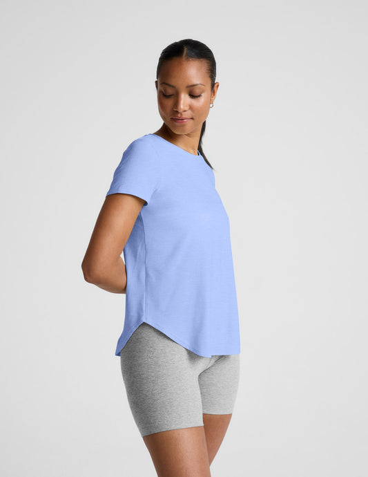 Woman wearing a light blue t-shirt and gray biker shorts against a plain background.