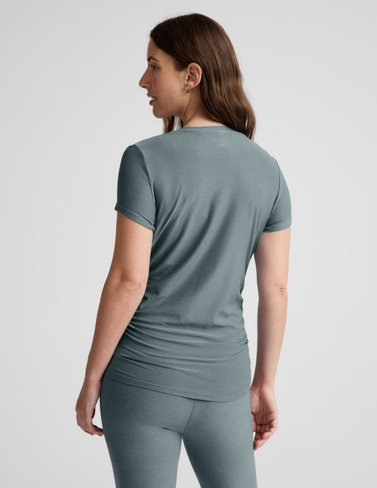 Woman wearing a gray athletic outfit on a light gray background.