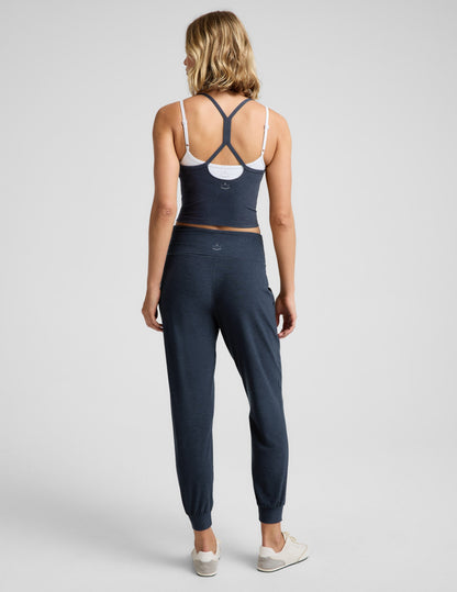 Woman wearing a blue tank top and blue joggers against a plain background.