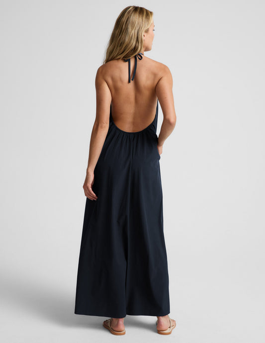 Woman wearing a navy blue halter maxi dress against a plain background.