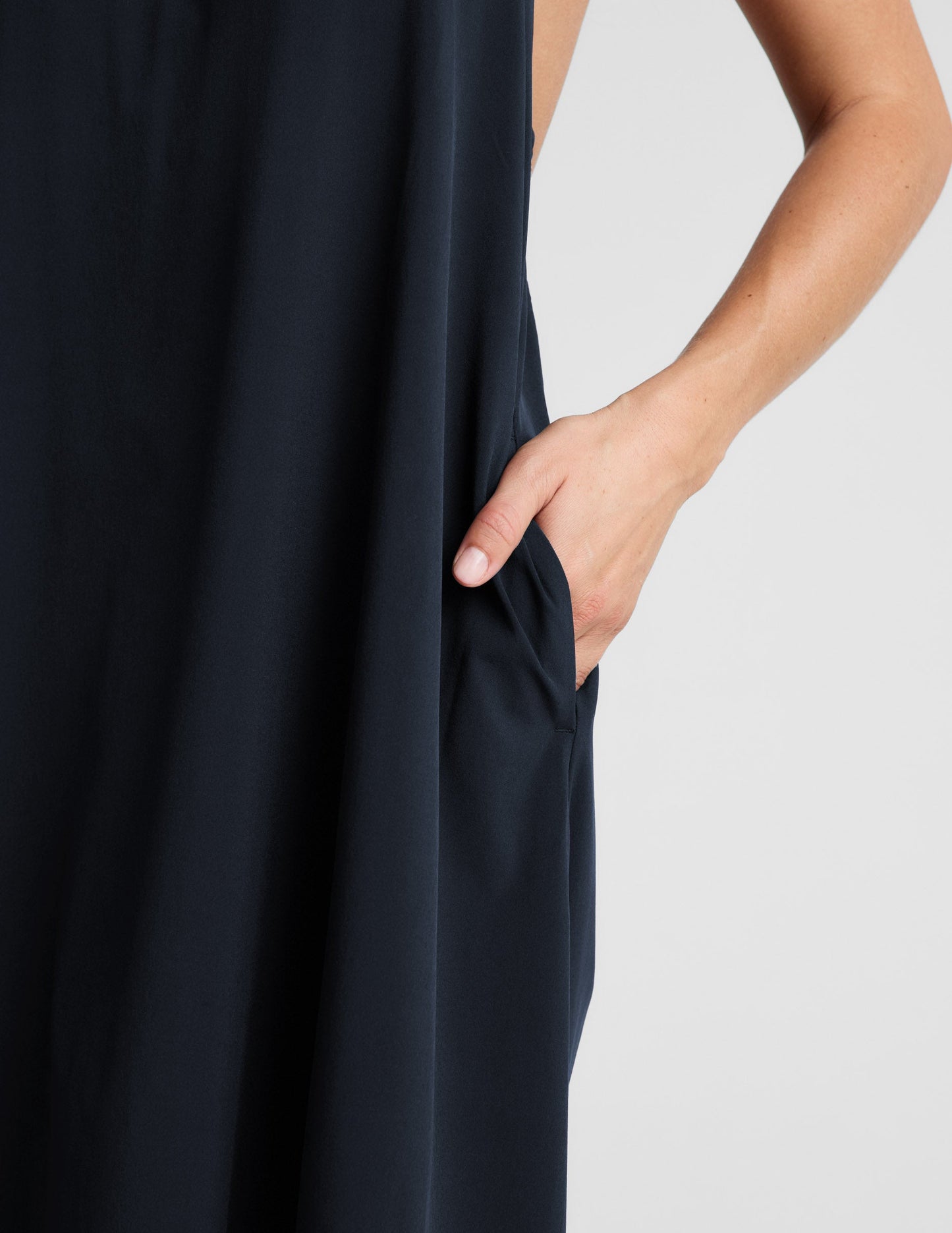 Woman wearing a navy blue halter maxi dress against a plain background.