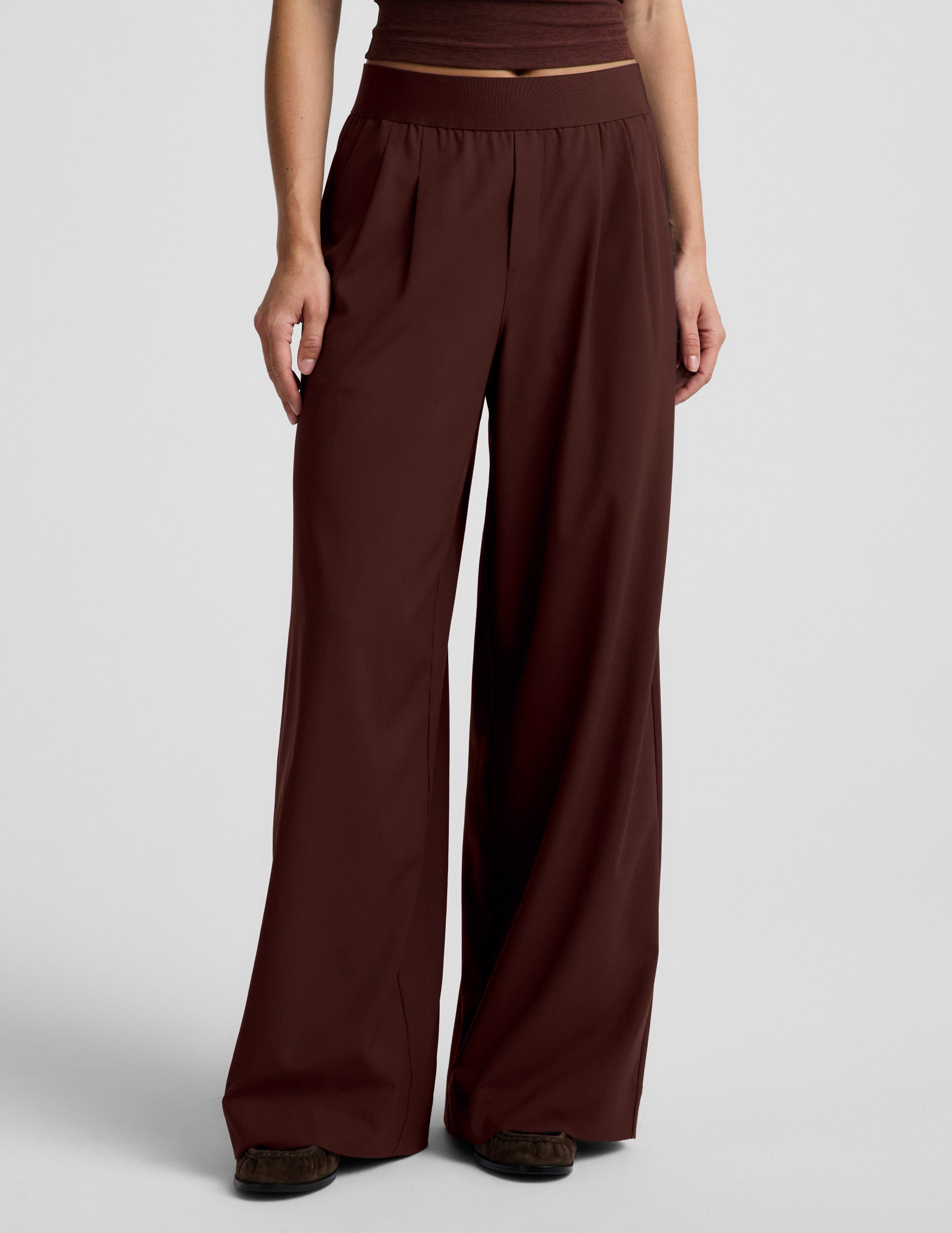 Woman wearing Brown Elasticated Wide Leg Pant 29" with front pleats, paired with a matching brown cropped top and shoes.