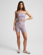 Woman wearing Sunwashed Gingham SoftMark™ Keep Pace Biker Short with a matching cropped tank and cream sneakers.