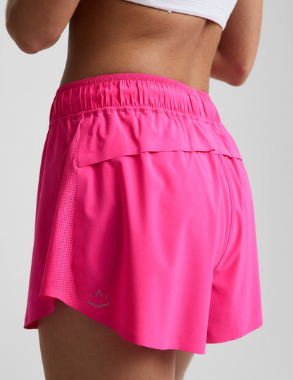Woman wearing Pink Solemate™ 2.5" Short with a white top, rear view showing vented back panel and perforated side panels.