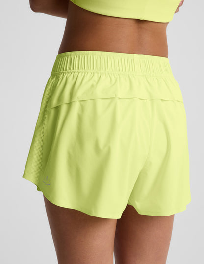 Woman wearing Yellow Solemate™ 2.5" Short, rear view, paired with a matching yellow top, showing the vented back panel.