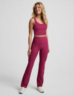Woman wearing Fuchsia Spacedye™ High Waisted Practice Pocket Bootcut Pant 31" with a matching tank and white sneakers.