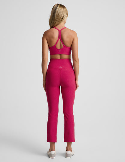 Woman wearing Fuchsia Spacedye™ Pintuck Kick Flare High Waisted Pant, rear view, paired with a matching sports bra.