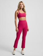 Woman wearing Fuchsia Spacedye™ Pintuck Kick Flare High Waisted Pant with a matching crop top and cream sneakers.