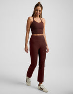 Woman wearing Maroon Spacedye™ Pintuck Kick Flare High Waisted Pant with a matching crop tank and cream sneakers.
