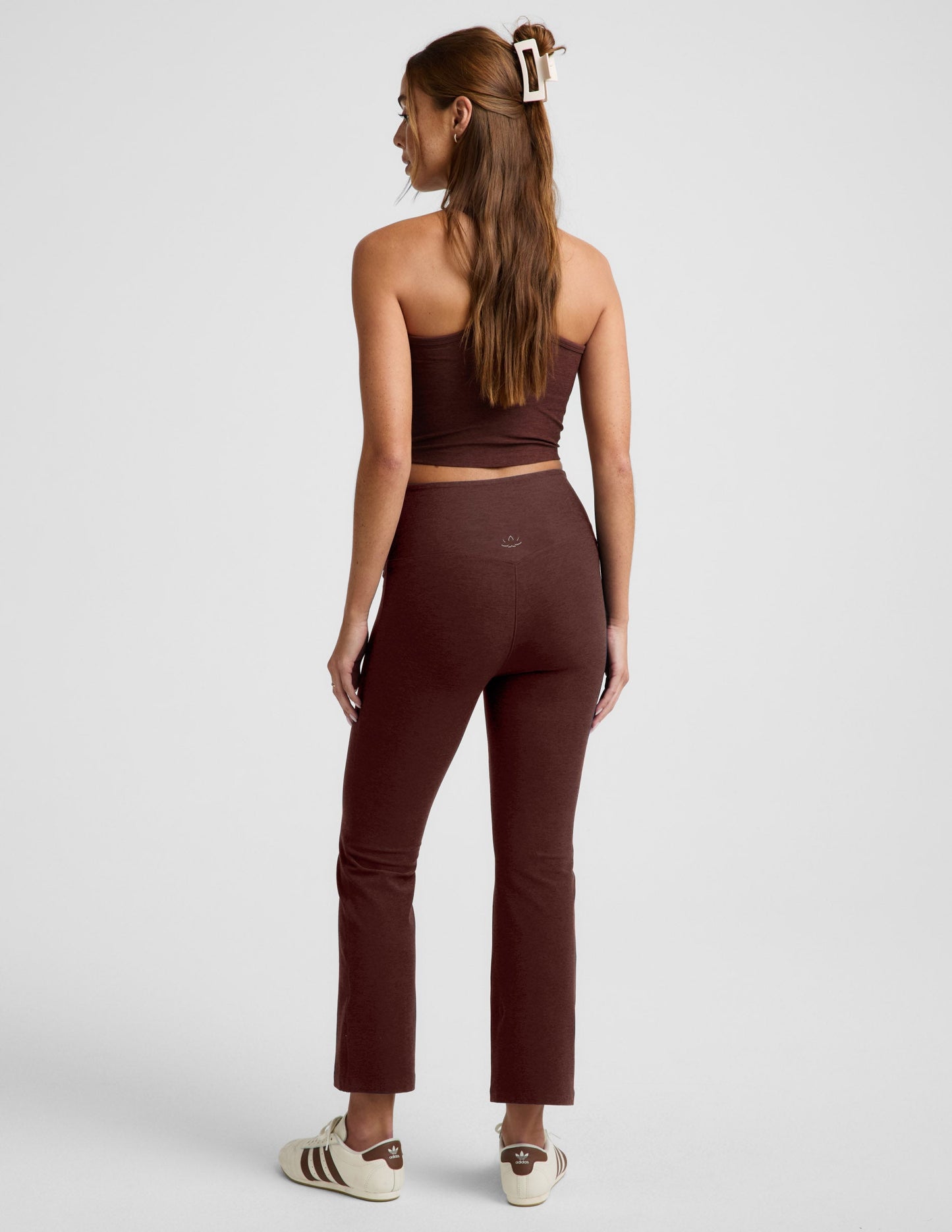 Rear view of woman wearing Maroon Spacedye™ Pintuck Kick Flare High Waisted Pant with a matching tube top and cream sneakers.