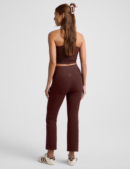 Rear view of woman wearing Maroon Spacedye™ Pintuck Kick Flare High Waisted Pant with a matching tube top and cream sneakers.