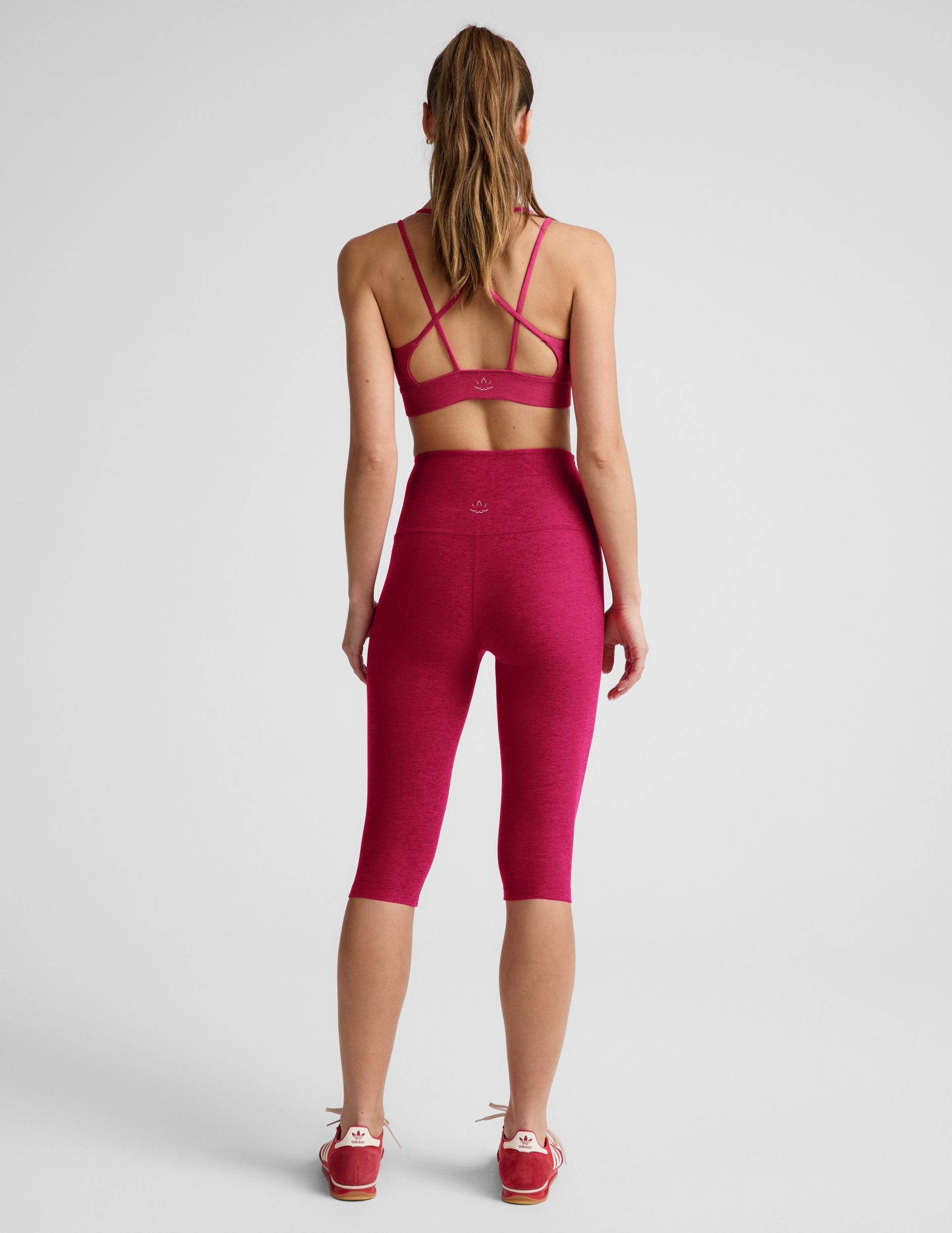 Woman wearing Fuchsia Spacedye™ Pedal Pusher High Waisted Legging paired with a matching sports bra, Rear view.