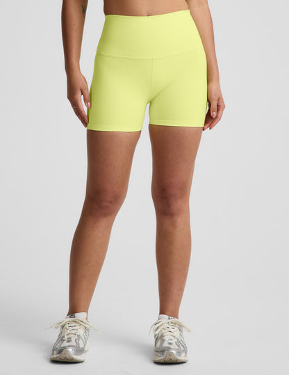 Woman wearing Yellow Spacedye™ Keep Pace 3" Short with a high waistband, paired with white and silver sneakers.